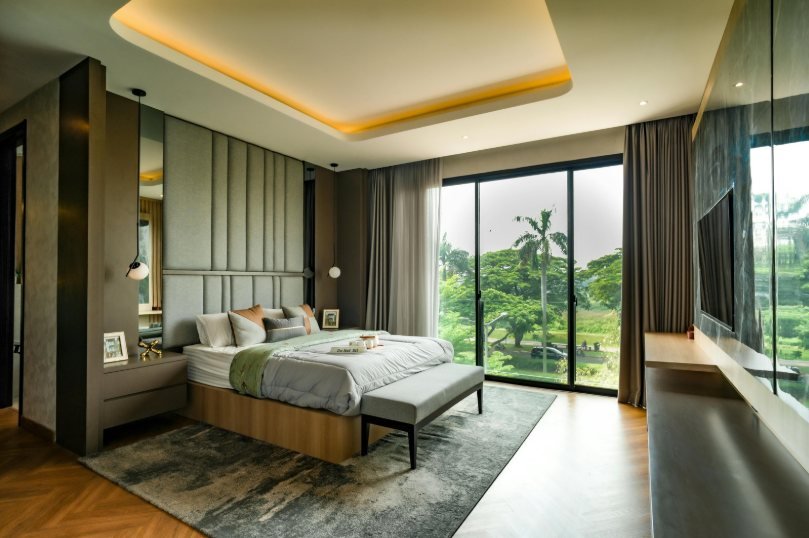 Bedroom with a window wall and cove-lit ceiling