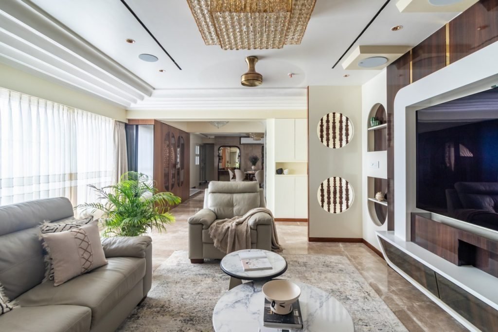 Living room with a sculptural TV wall and soft grey seating