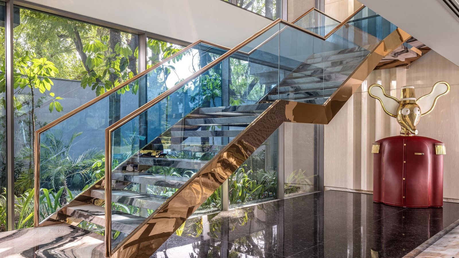 Glass and metal staircase opening toward a garden