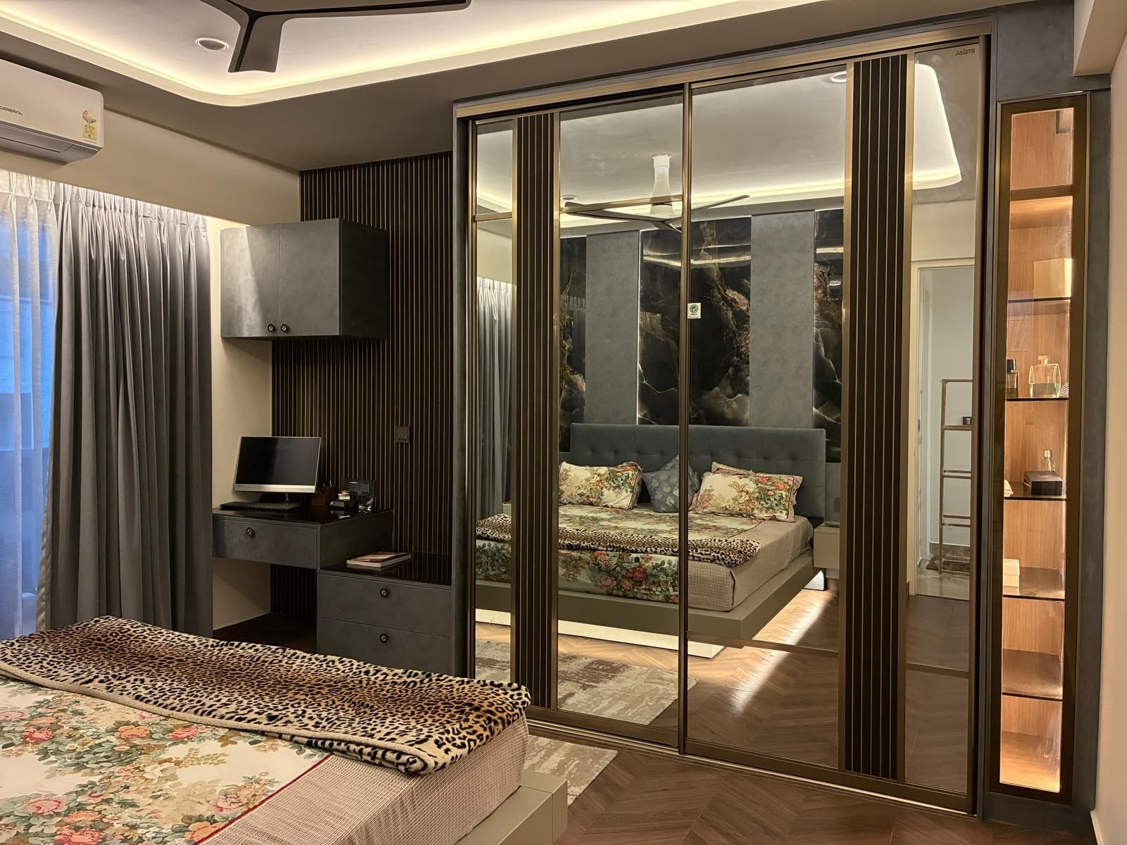 Bedroom with a mirrored wardrobe and fluted wood panels
